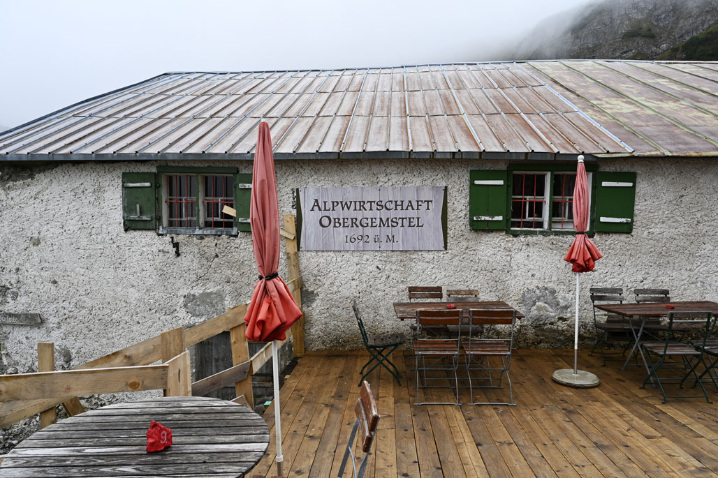 Ein Steinhaus mit kleinen Fenstern und Holzveranda im Nebel